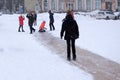 Happy kids are riding with a frozen slide on the weekend in the village .