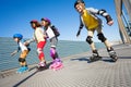 Happy kids rollerblading on the road at sunny day