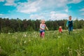 Happy kids run and play in summer nature, brother and sisters have fun