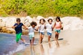 Happy kids running together along sandy beach Royalty Free Stock Photo