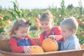 Happy kids sitting inside wheelbarrow at field pumpkin patch Royalty Free Stock Photo