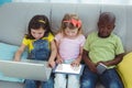 Happy kids sitting together with a tablet Royalty Free Stock Photo