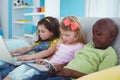 Happy kids sitting together with a tablet and laptop and phone Royalty Free Stock Photo