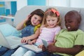 Happy kids sitting together with a tablet and laptop and phone Royalty Free Stock Photo