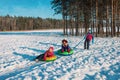 Happy kids slide in winter snow, boy and girls have fun outside Royalty Free Stock Photo