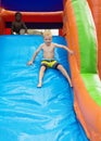 Happy kids sliding down an inflatable bounce house Royalty Free Stock Photo