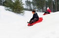 happy kids sliding on sleds down hill in winter Royalty Free Stock Photo