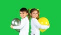 Happy kids smiling and hugging balloons on a green background. Happiness and emotion concept for your advertisment
