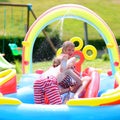 Happy kids splashing in inflatable garden pool Royalty Free Stock Photo