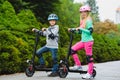 Happy kids standing on electric scooter outdoor