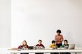 Happy kids with their African American female science teacher with laptop programming electric toys and robots at robotics