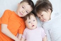 Happy kids, three laughing children different ages lying, portrait of boy, little girl and baby girl, happiness in childhood