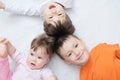 Happy kids, three laughing children different ages lying, portrait of boy, little girl and baby girl, happiness in childhood Royalty Free Stock Photo