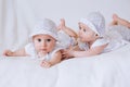 Happy kids twins in funny hats on a white background