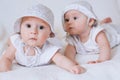 Happy kids twins in funny hats on a white background