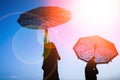 Happy Kids with an umbrella silhouette on nature in the park sunset