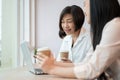 A happy and kind senior Asian businesswoman is working with a young female colleague in the office