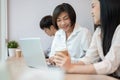 A happy and kind senior Asian businesswoman is working with a young female colleague in the office