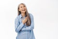 Happy korean senior woman, middle aged asian lady laughing and smiling, looking carefree, standing over white background Royalty Free Stock Photo