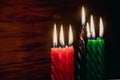 Happy Kwanzaa. African American holiday. Seven burning candles, red, black and green, in kinara candlestick. Royalty Free Stock Photo