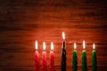 Happy Kwanzaa. African American holiday. Seven burning candles, red, black and green, in kinara candlestick. Royalty Free Stock Photo