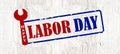 Happy Labor Day background greting card template - Grunge scratched stamp with wrench working symbols, isolated on rustic white Royalty Free Stock Photo