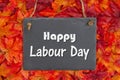 Happy Labour Day On A Chalkboard And Fall Leaves