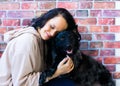 Happy lady in casual wear hugging purebred pet dog, mudi with owner over studio background.