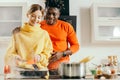 Happy lady cooking and boyfriend standing behind her back