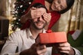 Pretty lady making surprise to her boyfriend on Christmas eve Royalty Free Stock Photo