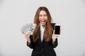 Happy lady holding money and smartphone and screaming isolated Royalty Free Stock Photo