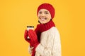 Happy lady holds cup of hot coffee on yellow background Royalty Free Stock Photo