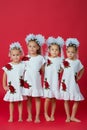 Happy large family of four sisters in embroidered white dresses on a plain red background in the studio Royalty Free Stock Photo