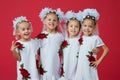 Happy large family of four sisters in embroidered white dresses on a plain red background in the studio Royalty Free Stock Photo