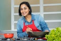 Happy latin american woman preparing vegetarian food