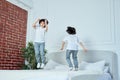 Jump higher. Happy latin boys, little brothers having fun together, jumping on the bed at home Royalty Free Stock Photo