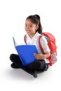 Happy latin child reading textbook or notepad smiling sitting on the floor