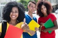 Happy latin female student with curly black hair and friends Royalty Free Stock Photo