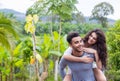 Happy Latin Man Carry Woman On Back, Young Couple Over Green Tropical Rain Forest Landscape Royalty Free Stock Photo