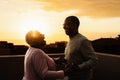 Happy Latin senior couple having romantic moment on rooftop during sunset time Royalty Free Stock Photo