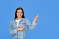 Happy Latin teen girl pointing aside standing isolated on blue background. Royalty Free Stock Photo