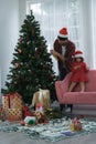 Happy latino family, young bearded father wear santa hat and little daughter decorating a Christmas tree together at home Royalty Free Stock Photo