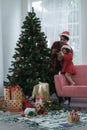 Happy latino family, young bearded father wear santa hat and little daughter decorating a Christmas tree together at home Royalty Free Stock Photo