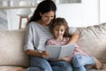 Happy Latino mom and daughter read book at home Royalty Free Stock Photo