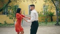 Happy latino performers dancing sensual energetic dance in front town building. Royalty Free Stock Photo