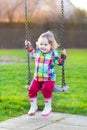 Happy laughing baby girl on swing in garden Royalty Free Stock Photo