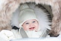 Happy laughing baby girl in a warm stroller Royalty Free Stock Photo