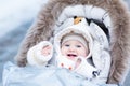 Happy laughing baby girl in warm stroller Royalty Free Stock Photo