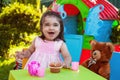 Happy laughing baby toddler girl playing in outdoor tea party with best friend Teddy Bear Royalty Free Stock Photo