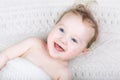 Happy laughing baby under a knitted blanket Royalty Free Stock Photo